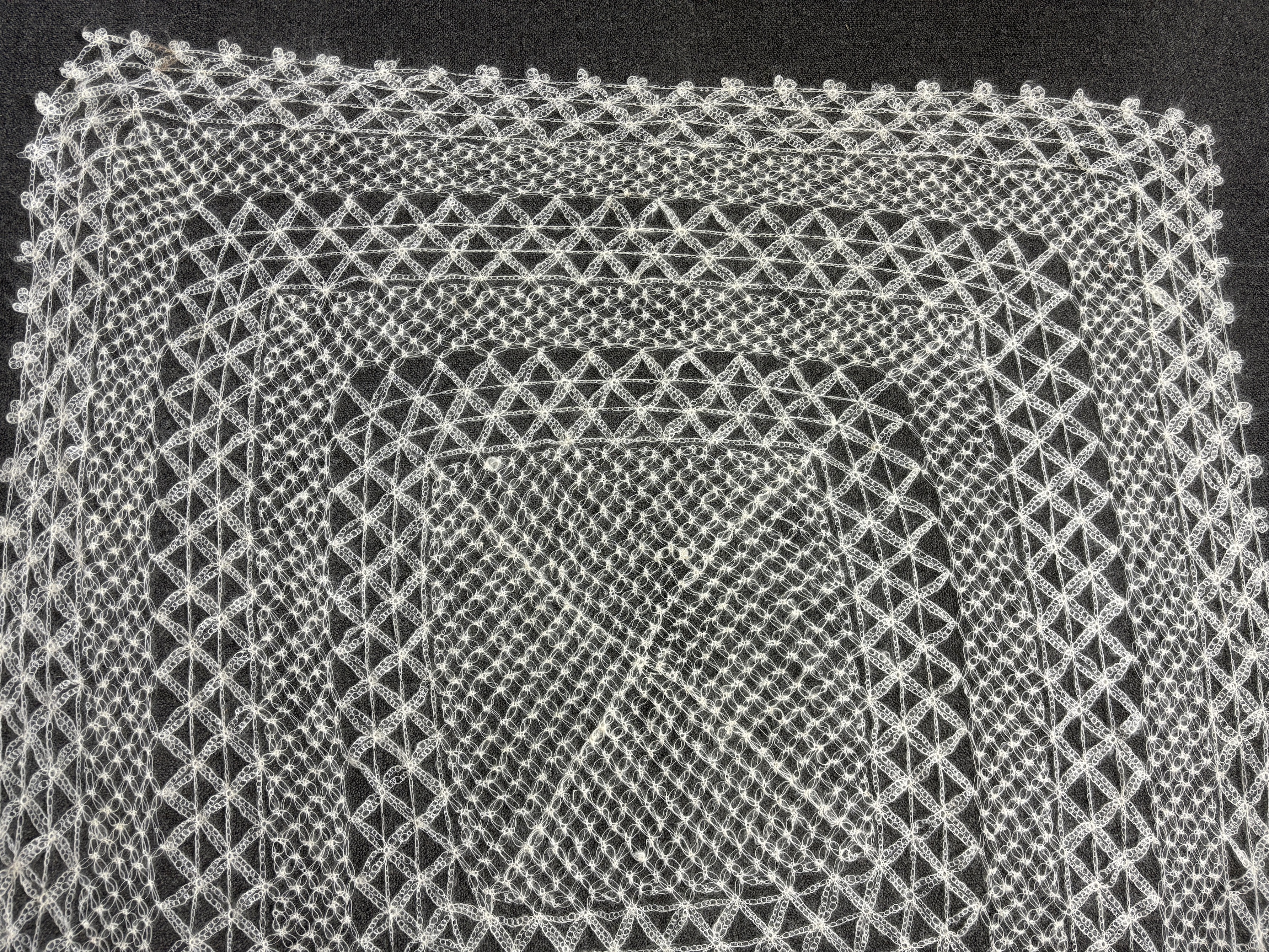 A 20th century central Turkish hand spun and knitted mohair shawl, knitted in an open geometric lace design in cream, 116cm x 120cm